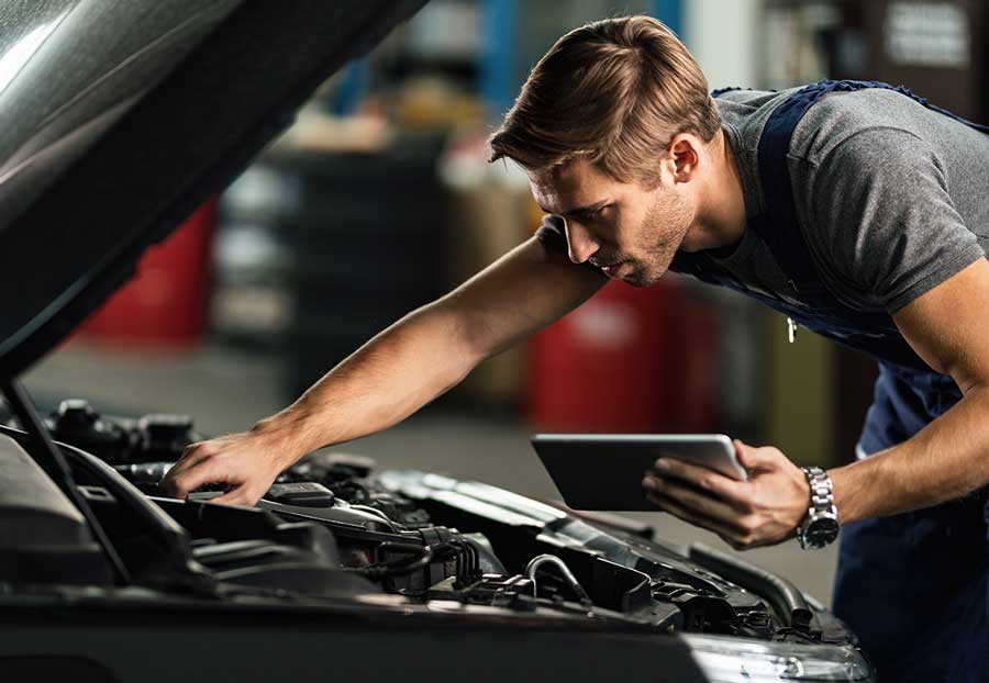 A man looking at the engine of his car