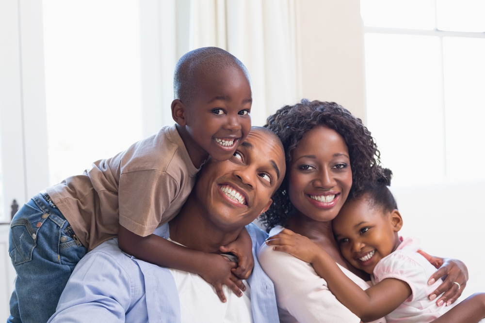 A family of four is smiling for the camera.