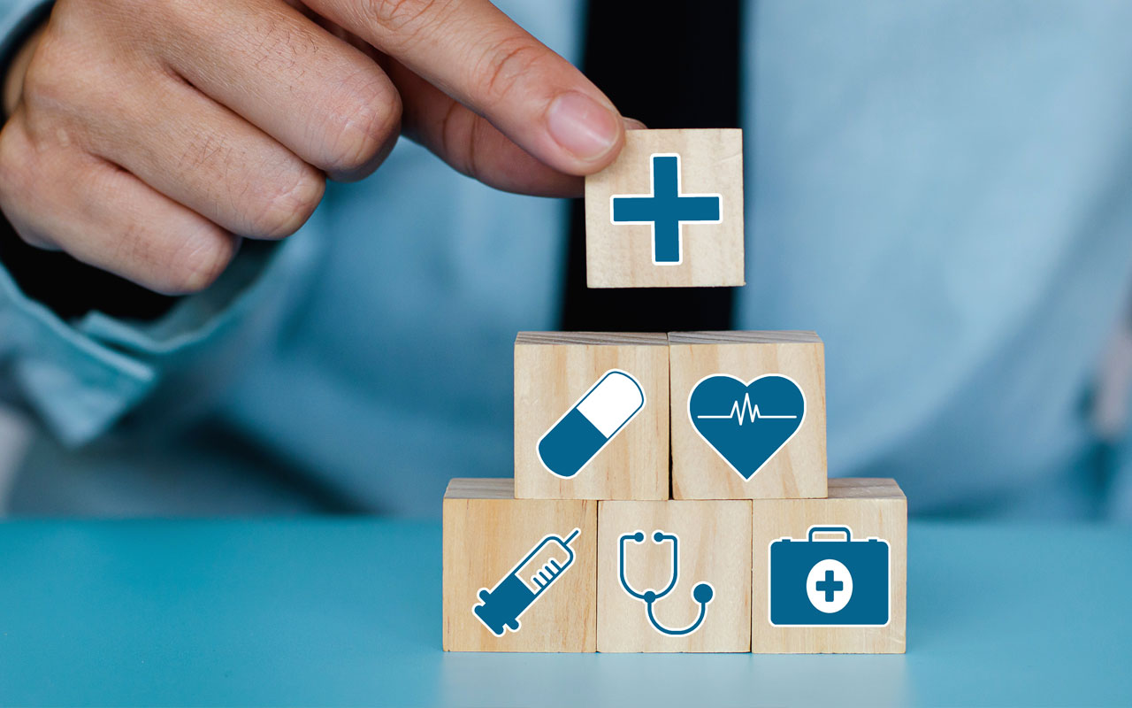 A person is holding blocks with medical icons on them.